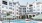 Sparkling swimming pool with green and white umbrellas and cabanas with the apartment building in the background